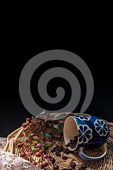 Wicker basket With lace Cup blue and coffee beans black background some light