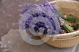 Wicker basket with lavender flowers on cement floor, closeup