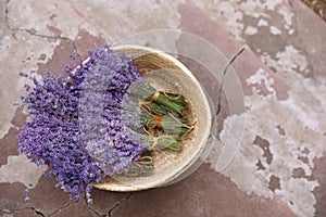 Wicker basket with lavender flowers on cement floor, top view. Space for text