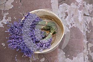 Wicker basket with lavender flowers on cement floor outdoors. Space for text