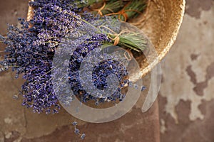 Wicker basket with lavender flowers on cement floor outdoors