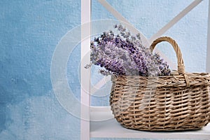 Wicker basket with lavender flowers on shelf