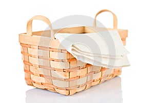 Wicker basket and napkin on white