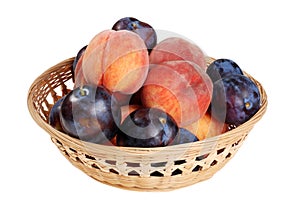 Wicker basket of peaches and plums