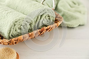 Wicker basket with rolled towels on table