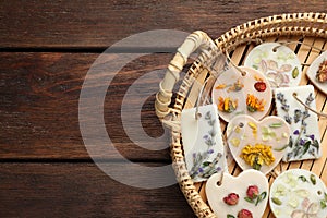 Wicker basket with scented sachets on wooden table, top view. Space for text