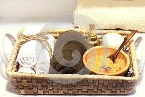 Wicker basket with a set for spa treatments, sea salt, aroma oil, stones, candle and soft towels