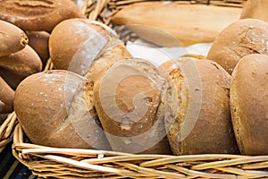 A wicker basket with several pieces of handmade bread