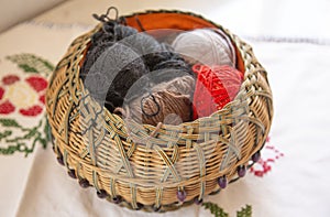 Wicker basket on a table with wool balls