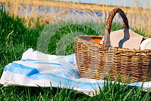 basket on the tablecloth on a background of green grass ,picnic concept