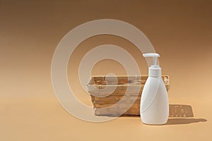 Wicker basket and white dispenser bottle, for spa cosmetic products on a beige background