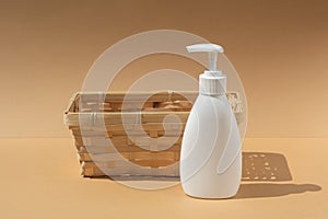 Wicker basket and white dispenser bottle, for spa cosmetic products on a beige background