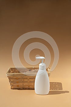 Wicker basket and white dispenser bottle, for spa cosmetic products on a beige background