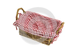 Wicker basket with a white/red checkered textile on white background.