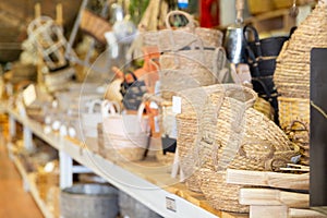 Wicker baskets and other handmade items on store shelves close up