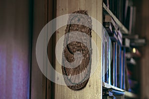 Wicker bast shoes hanging on a wooden bookshelf