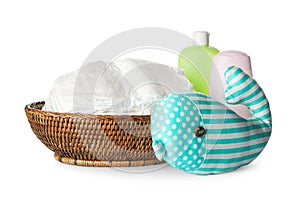 Wicker bowl with disposable diapers, toy and toiletries on background