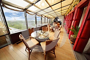 Wicker chairs and glass tables in restaurant photo