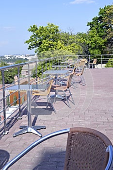 Wicker chairs with metal legs and racks are in an open cafe area