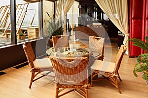 Wicker chairs and table in restaurant photo