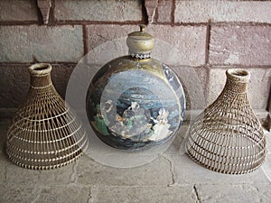 Wicker cloches and antique decorative painted metal vase photo