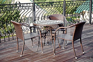 Wicker furniture on the veranda in the summer cafe. Table and chairs, cafe without visitors.