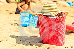 Wicker handbag bag and hat on summer beach.