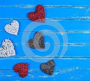 Wicker hearts on a blue wooden plank background