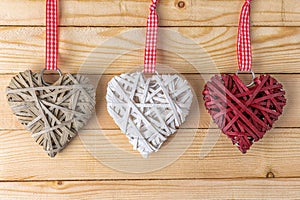 Wicker hearts made of straw on wooden background with copy space. Valentine day or love concept