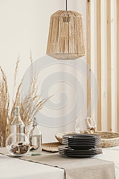 Wicker lamp above the table in real photo of dining room