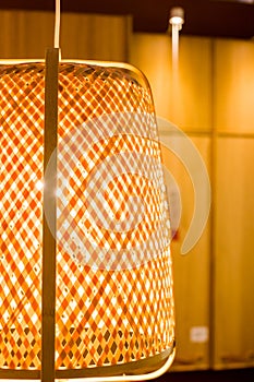 Wicker lamp hanging from the ceiling gray background.Texture of rattan lamp, closeup.