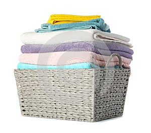 Wicker laundry basket with clean towels on white