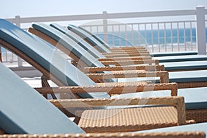 Wicker lounge chairs poolside by the beach