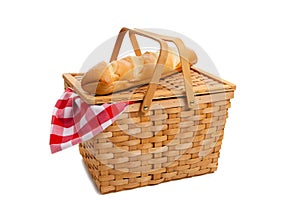 Wicker picnic basket with bread on white