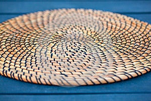 Wicker plate holde on table. Details of wicker plate. Selective focus photo