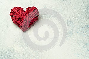 Wicker red heart decor on a light background with place for text