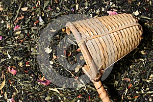 Wicker scoop over a tea leaves background