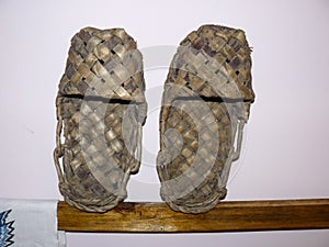 Wicker shoes bast shoes. Bast shoes on a stand.