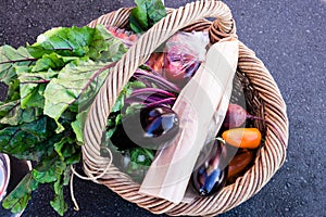 Wicker shopping basket of fresh vegetables and produce at a farm