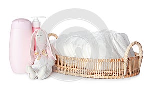 Wicker tray with disposable diapers, toy bunny and toiletries on background