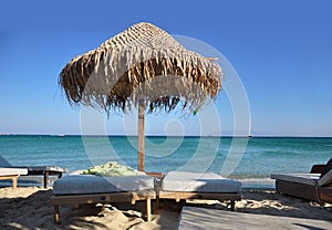 The wicker umbrella on the beach, the blue sky and the sea.