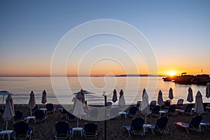 Wicker umbrella silhouette at Stoupa sandy beach at sunset. Mani Messenia, Greece Peloponnese