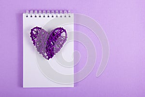 Wicker Valentine and white notes on a purple background. Handmade. Valentine`s Day.