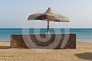 Wicker windbreak and umbrella on a beach beside the Red Sea