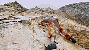 Wide angle bottom view Young fit woman rock climbing on sport route outdoors