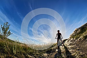 Wide angle of the cyclist with mountain bicyclist against beautiful landscape.