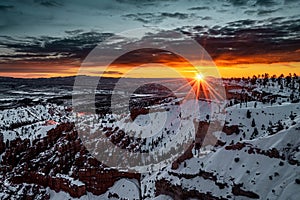 Wide-angle landscape shot of the beautiful Bryce Canyon National Park covered in snow during sunset