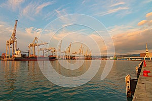 Wide angle landscape view of international cargo harbor of Koper. Empty container ship wait for loading by containers.