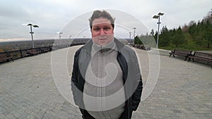 Wide angle lens: young fat man noticed hidden camera and looks in it