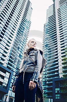 Wide angle low point of view, portrait of beautiful Caucasian white young bald girl woman with shaved hair head in leather jacket